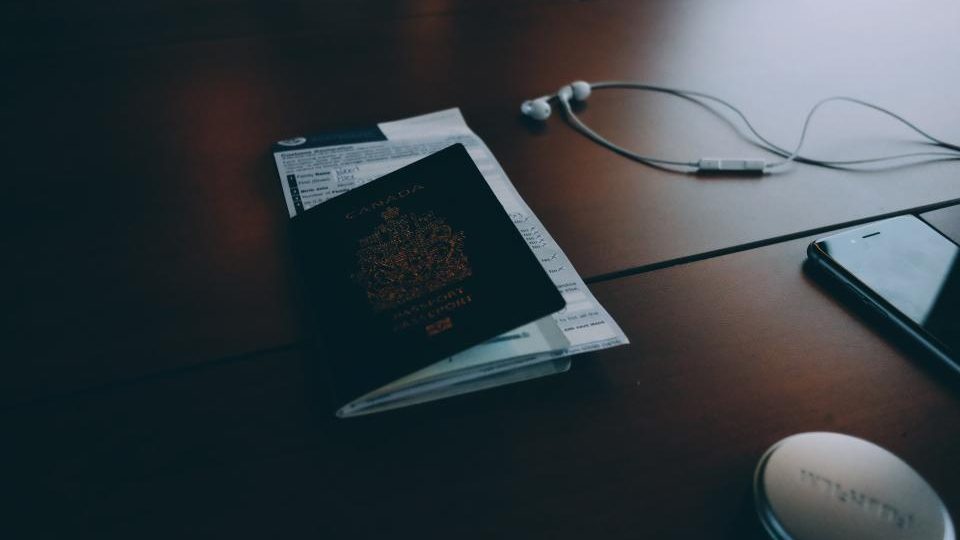 A passport and a customs declaration form on a dark wooden table